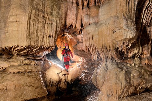 Grotte de l'Olivier (Lot) - Spéléo dans un conduit dans des grandes coulées de calcite (cadrage serré)(SP-23-1786)